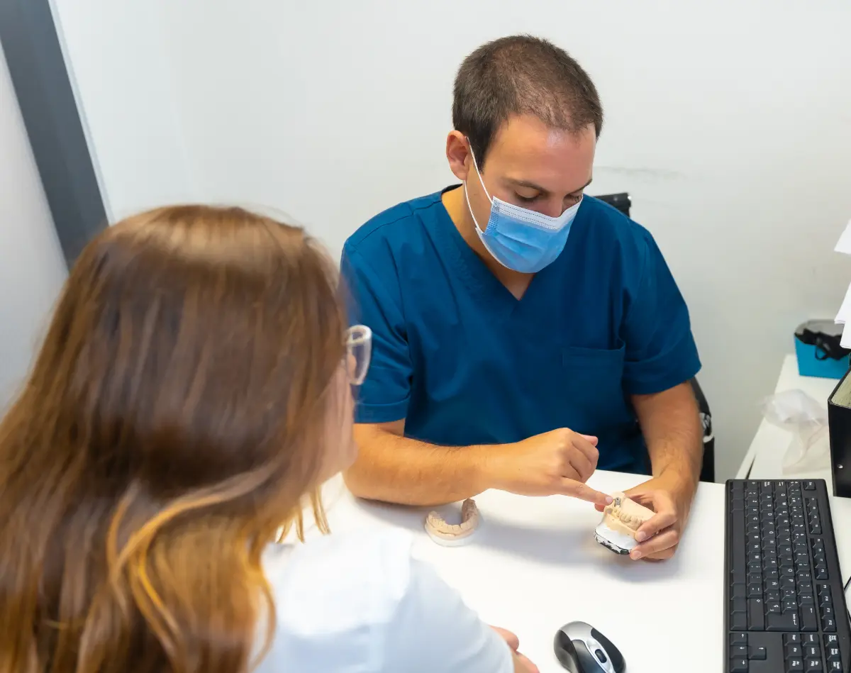Dentist explaining dental model to patient.