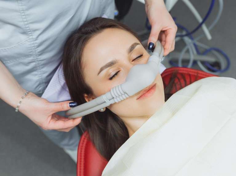 Patient receiving dental sedation with mask