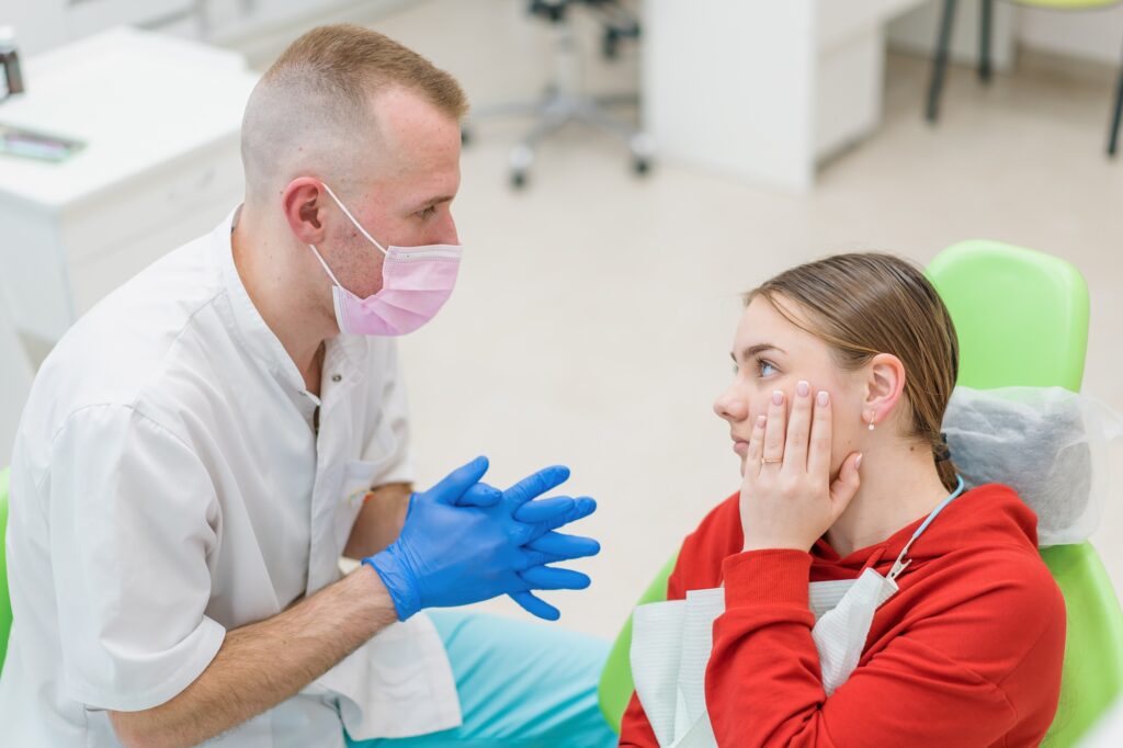 Dentist explaining the connection between oral health and overall wellness to a patient in Alexandria, VA