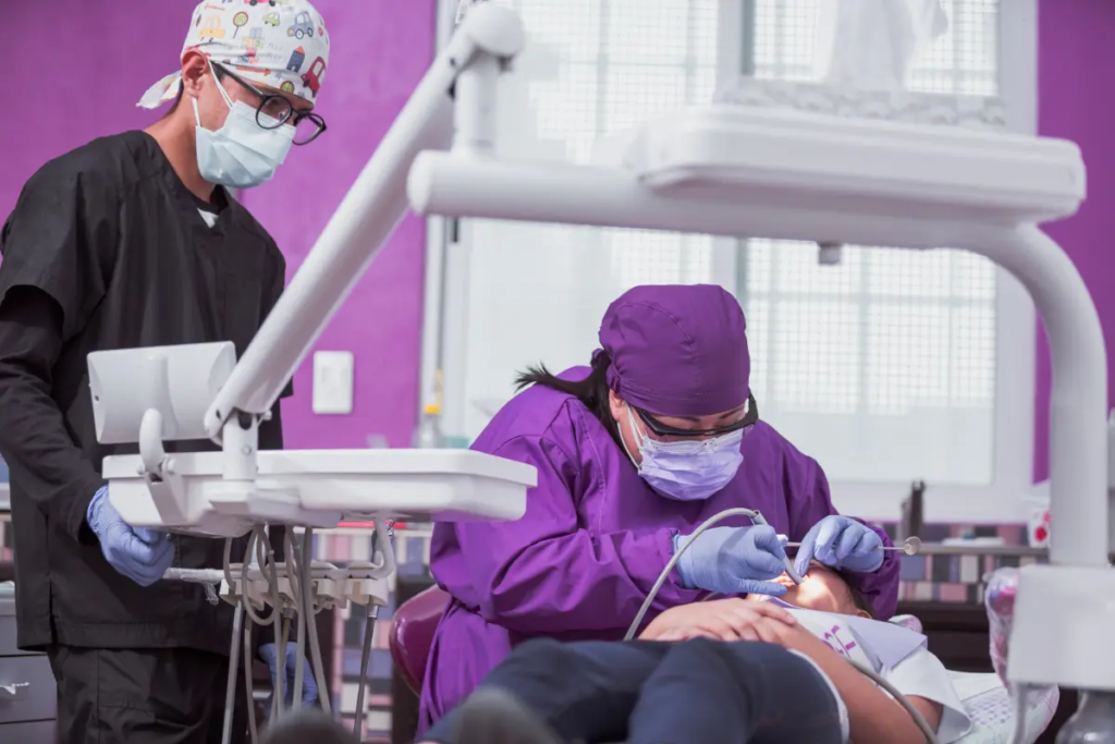 Dentists performing dental procedure on patient.